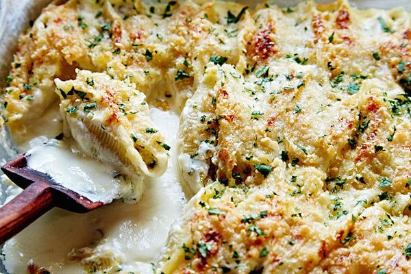 a casserole dish with cheese and spinach on it, ready to be eaten