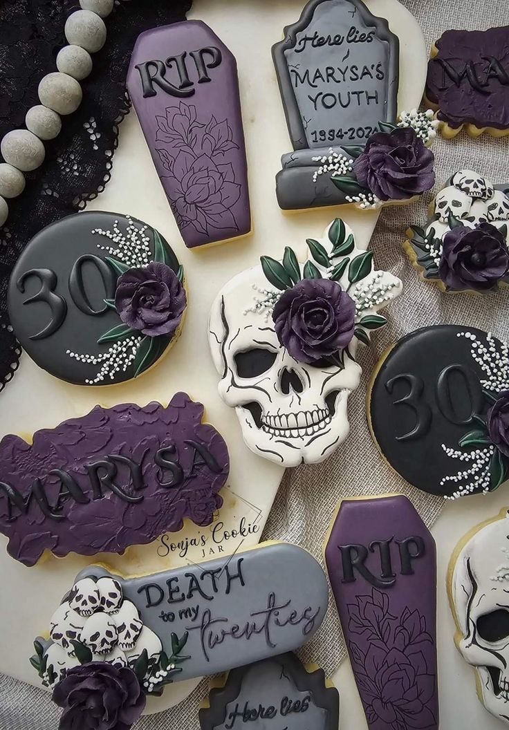 decorated cookies are arranged in the shape of skulls and tombstones with flowers on them