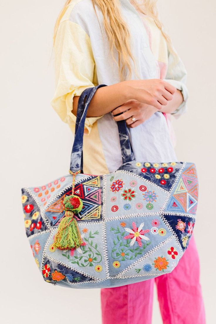 This one goes out to all our boho babes! The Arden is a colorful oversized tote that's sure to brighten up your day. This handmade piece features so many unique details, from the patchwork and tie-dye denim design to the bright fuchsia interior (no more digging in the endless abyss to find your keys). The Arden pairs well with all of your favorite summer activities: farmer's markets, getaways, beach time, and more! Details: 20” long x 14" height x 11” wide 3 interior pockets Patchwork denim deta Bohemian Bags For Everyday Spring, Bohemian Everyday Bags For Spring, Bohemian Blue Bags For Spring, Bohemian Spring Tote Bag, Bohemian Patchwork Bags For Summer, Hippie Multicolor Patchwork Bag, Bohemian Festival Bag With Patchwork, Spring Festival Embroidered Bags, Summer Beach Patchwork Bags