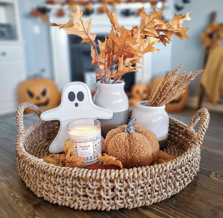 a wicker basket filled with candles and halloween decorations on top of a wooden table