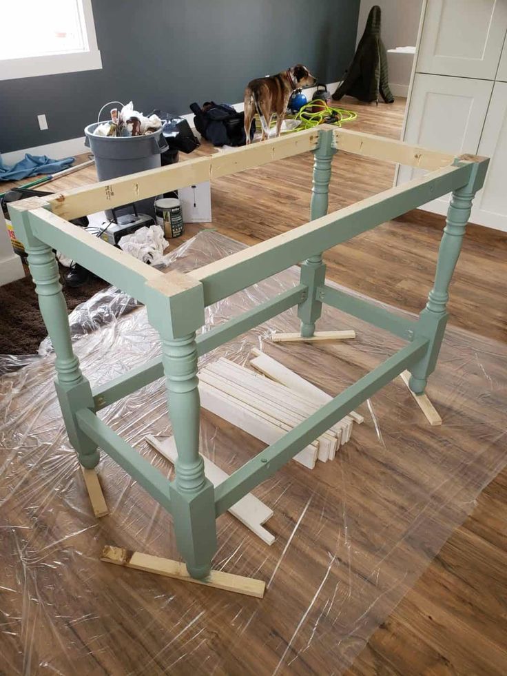 a table being constructed in the middle of a room with wood flooring on it