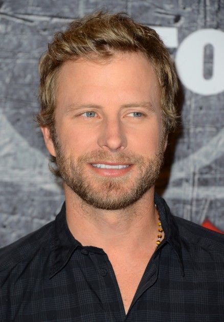 a close up of a person wearing a black shirt and smiling at the camera,