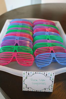 there are many pairs of colorful sunglasses on the table with a price tag for each pair