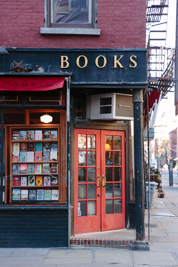 a book store on the corner of a street in front of a red brick building