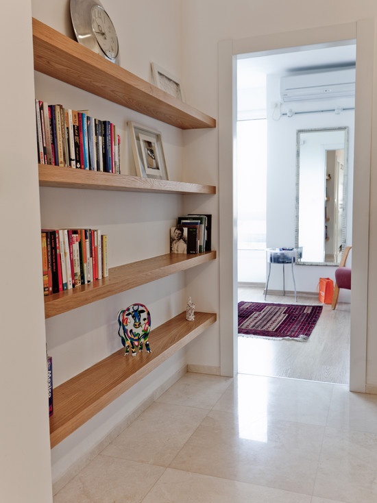 a room with bookshelves and a rug on the floor