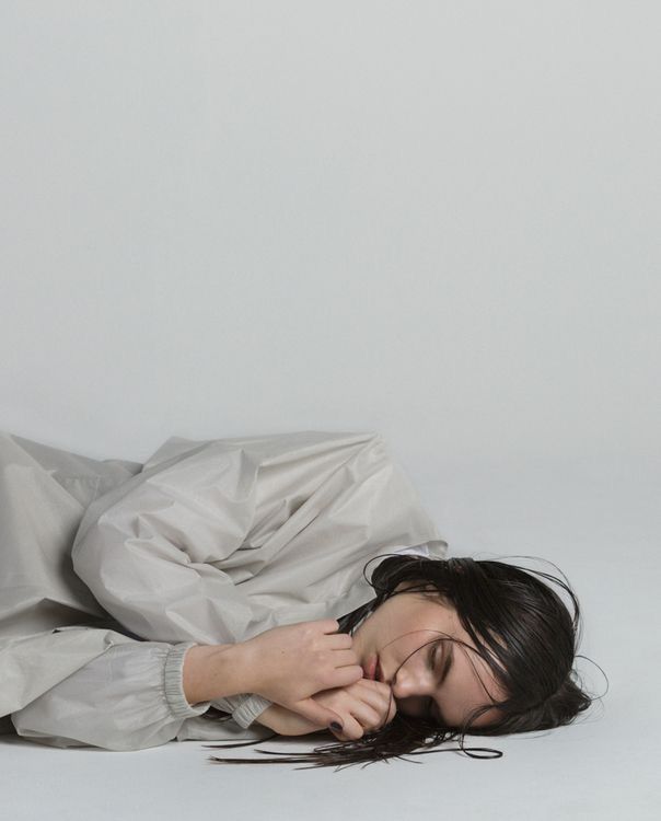 a woman laying on the ground with her head in her hands