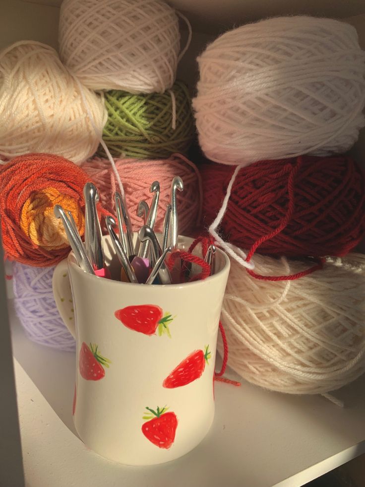 yarn and knitting needles in a cup on a shelf