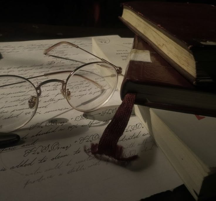 a pair of glasses sitting on top of an open book