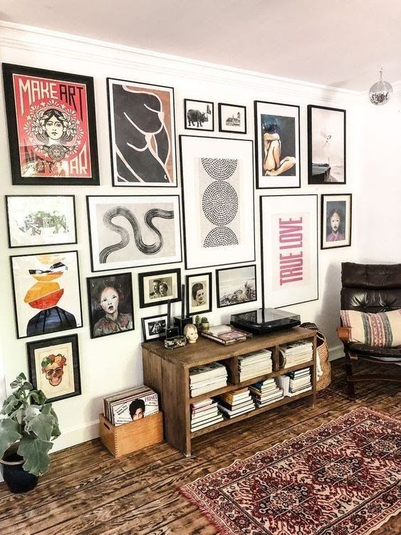 a living room filled with lots of framed pictures on the wall above a coffee table