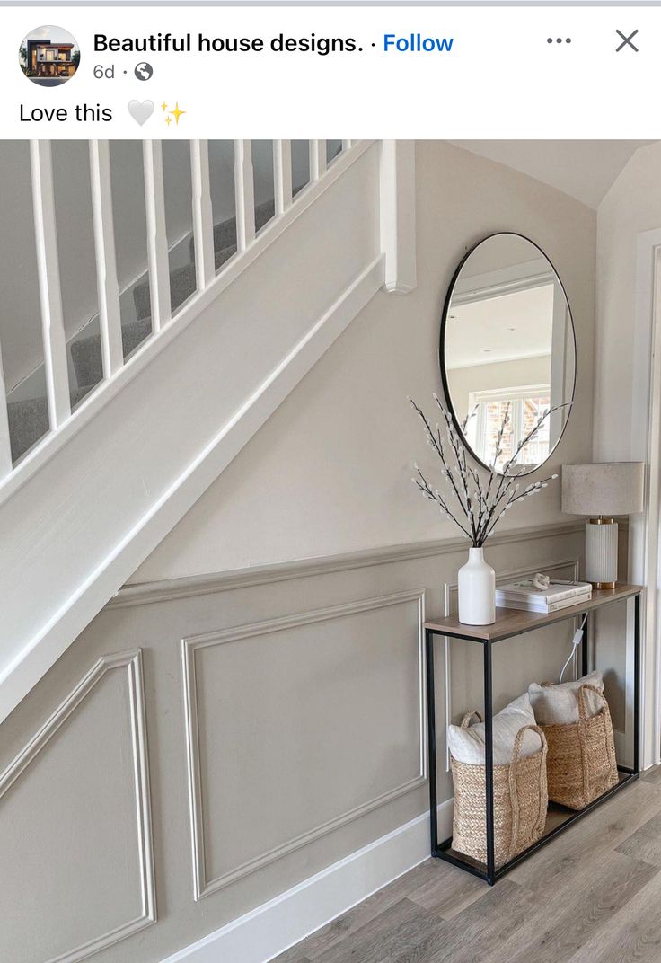 a white staircase with a mirror and some baskets on the side table next to it