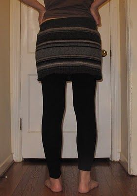 a woman standing in front of a door wearing leggings