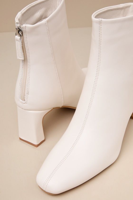 'Tis the season for falling leaves, cozy cardigans, and the Lulus Oceane Off White Ankle Booties! Smooth faux leather shapes these wardrobe-essential booties with a squared, pointed-toe upper and a seamed design. The ankle-high shaft boasts a 4.25"" pull-tab zipper at the heel for easy on-and-off, all atop a stylish blade heel. Available in whole sizes only. 2. 75" wrapped blade heel. Cushioned insole. Rubber sole has nonskid markings. Man Made Materials. Imported. Lulus | Oceane Off White Ankle Fitted Mid-calf Boots With Reinforced Heel For Fall, Spring Booties With Padded Ankle And Medium Width, Medium Width Heeled Boots For Fall, Winter Ankle Booties Medium Width, Fall Medium Width Faux Leather Booties, Chic Winter Booties With Reinforced Heel, Fall Boots With Padded Ankle And Block Heel, Fall Block Heeled Boots With Reinforced Heel, High Heel Faux Leather Fall Booties