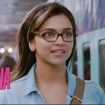 a woman wearing glasses standing in front of a train at a station with the words banana on it