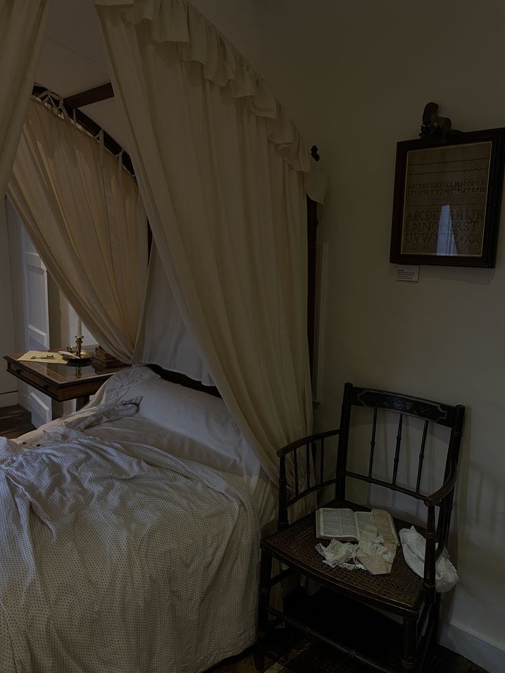 a bed sitting in a bedroom next to a window with curtains on top of it