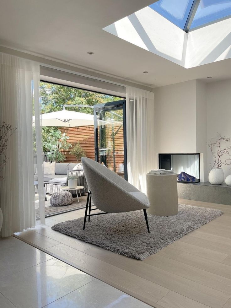 a modern living room with white furniture and large windows