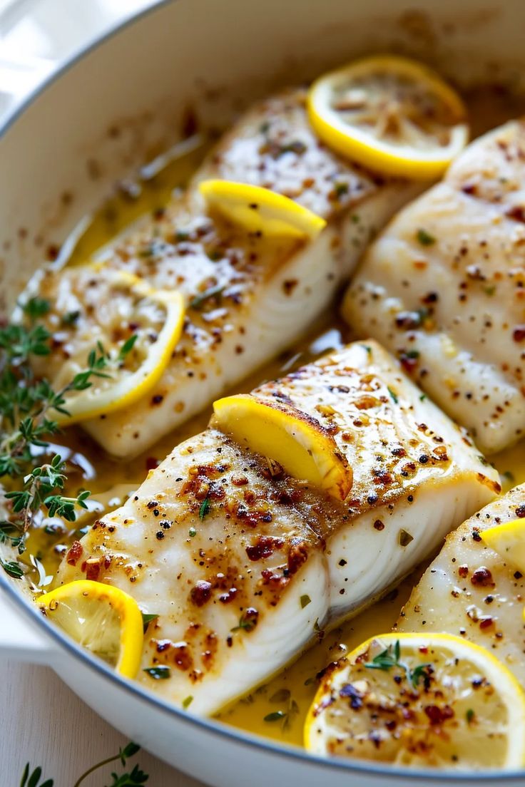 fish with lemons and herbs in a pan