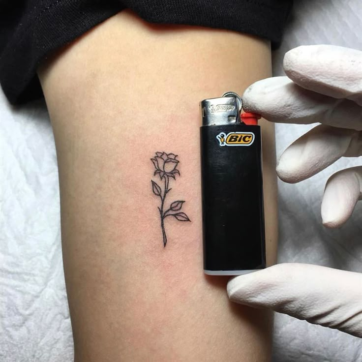 a woman's stomach with a small flower tattoo on it