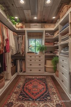 a walk in closet with lots of clothes and rugs on the floor next to it