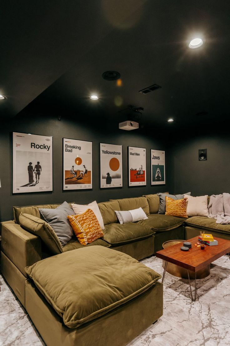 a living room with couches and pictures on the wall above them in a home theater