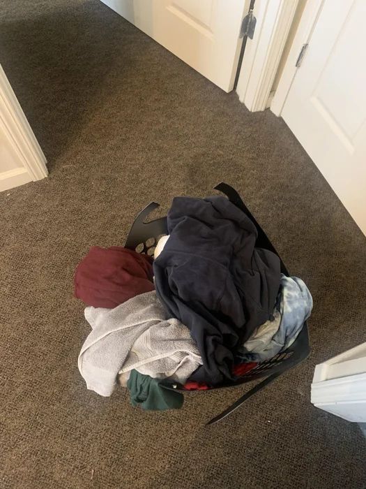 a pile of clothes sitting on the floor next to a door