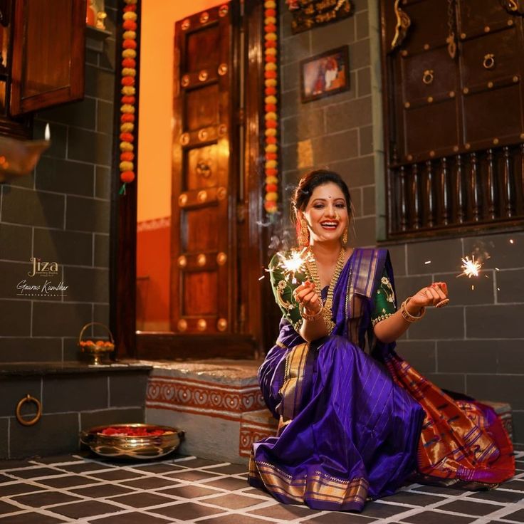 a woman sitting on the ground holding sparklers