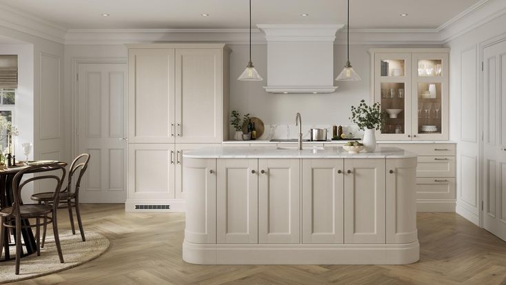 a large kitchen with white cabinets and wooden floors