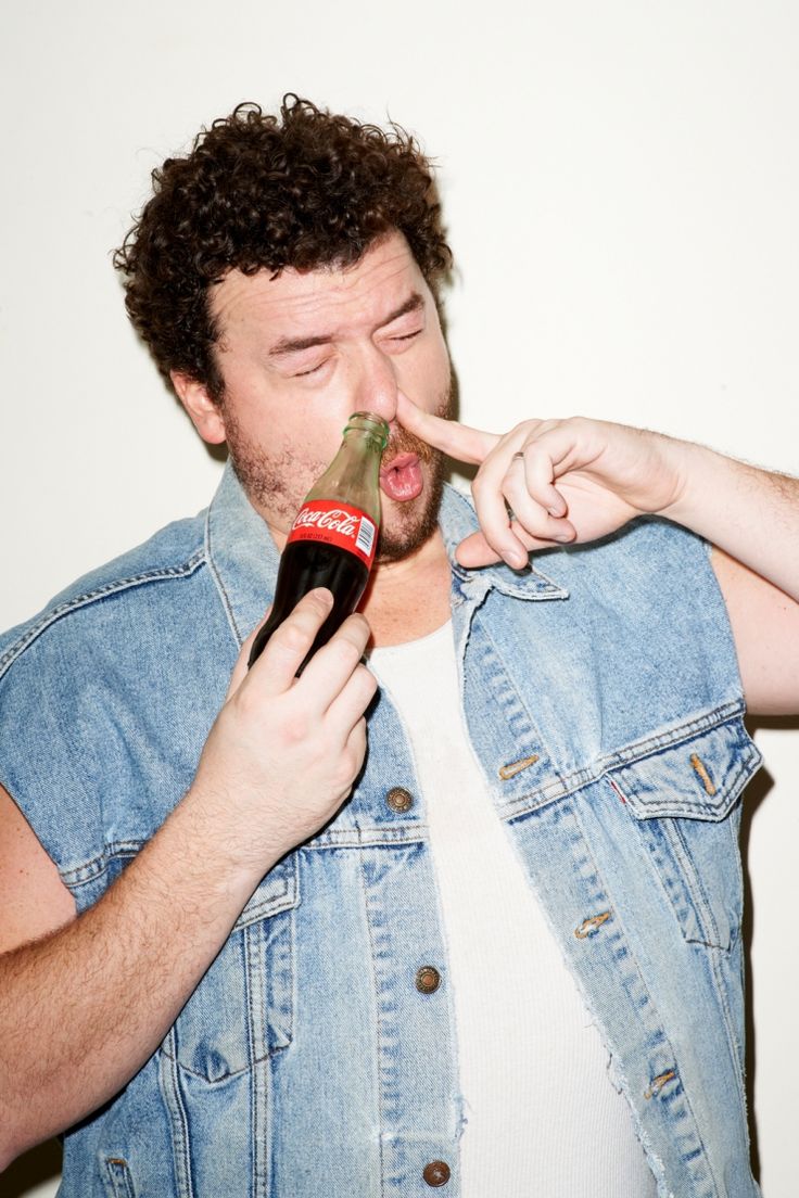 a man is holding a beer in his mouth