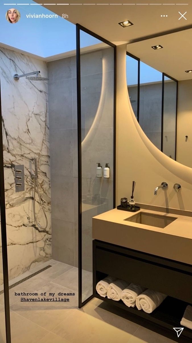 a bathroom with a sink, mirror and shower stall