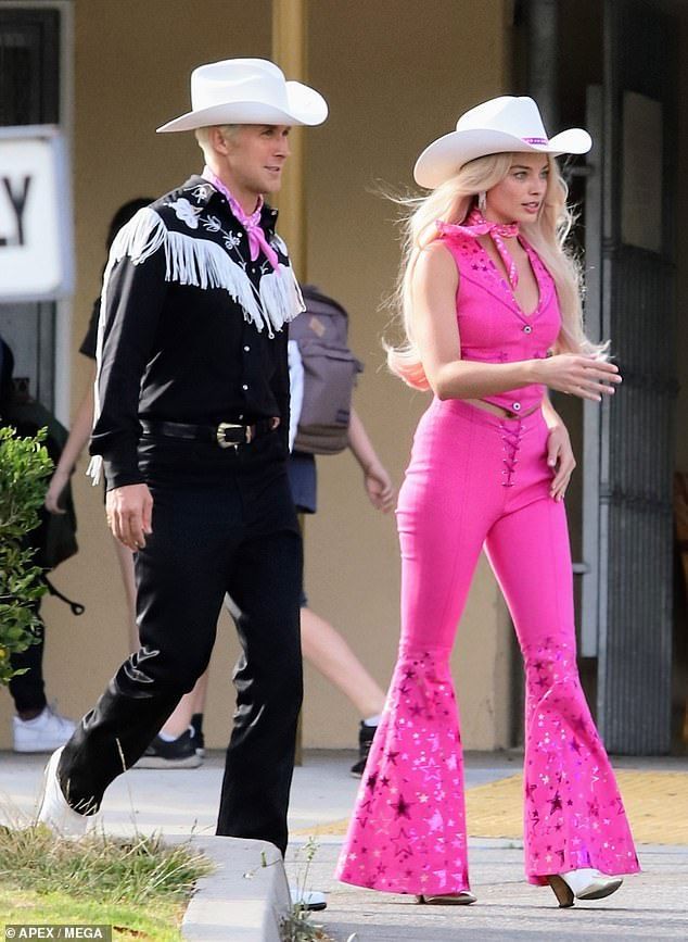 a man and woman in cowboy hats walking down the street