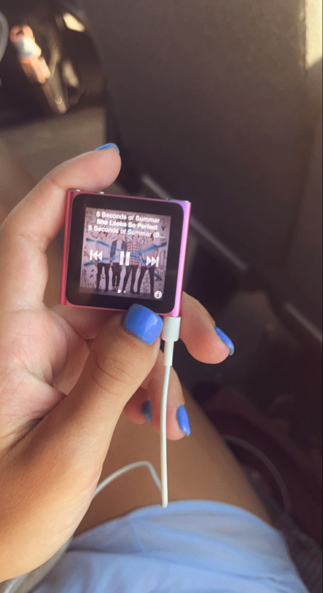 a person holding up a small mp3 player in their hand