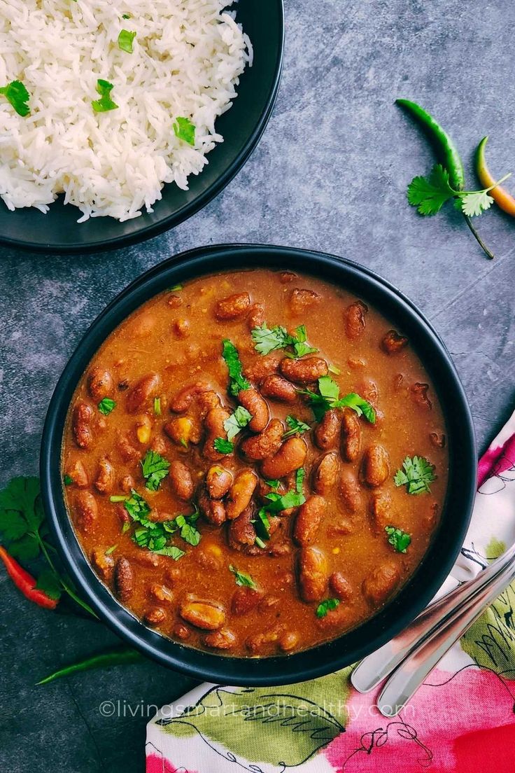 two bowls filled with beans and rice on top of a table