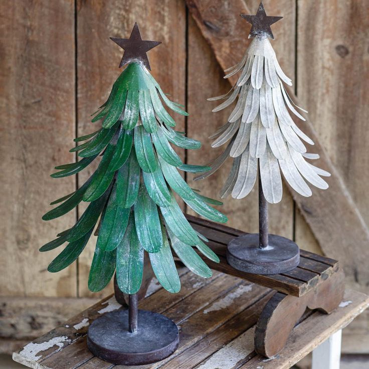 two wooden christmas trees sitting on top of a table