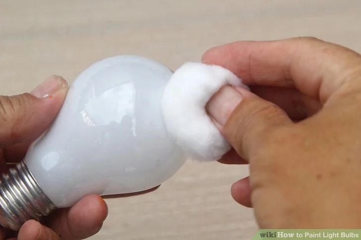 a person holding an electric light bulb in their hand with cotton on the inside of it