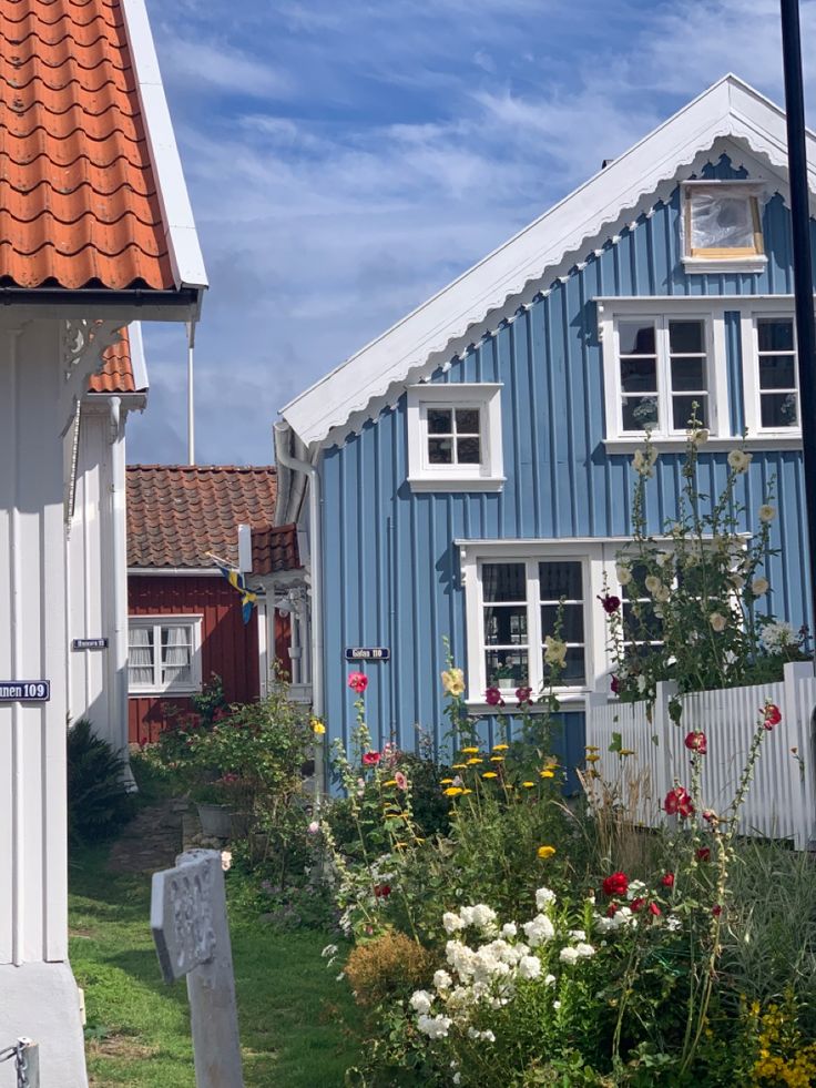 a blue house with white windows and red roof