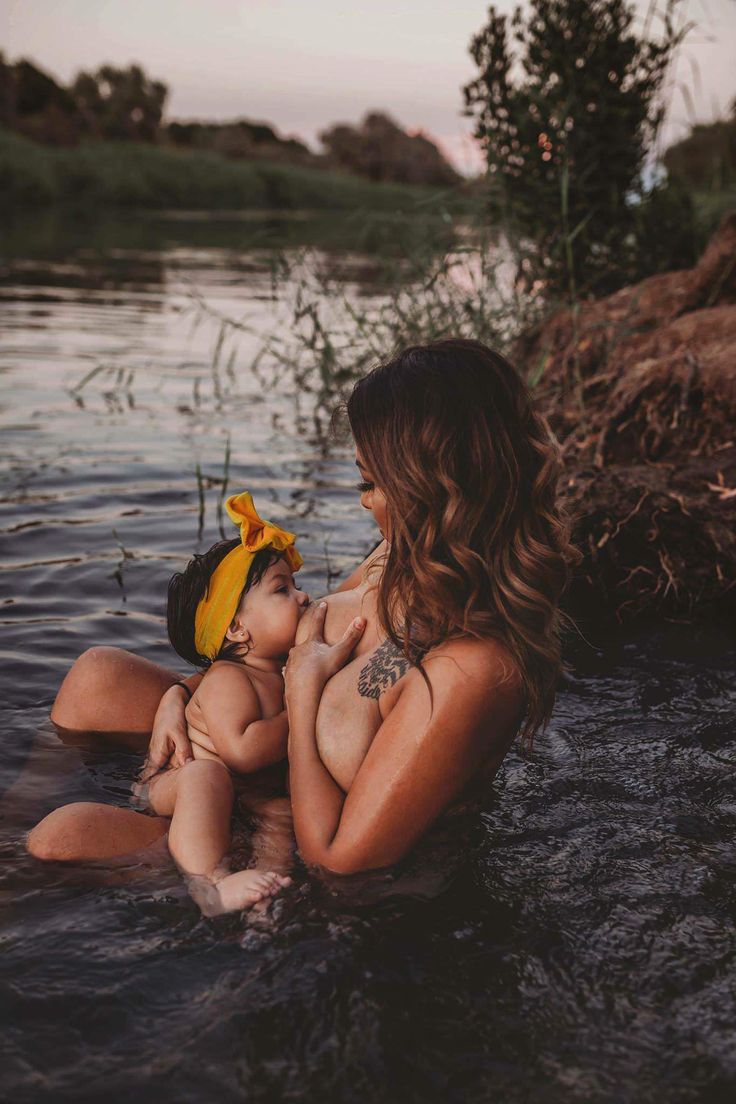 a mother and her baby are sitting in the water with their backs to each other