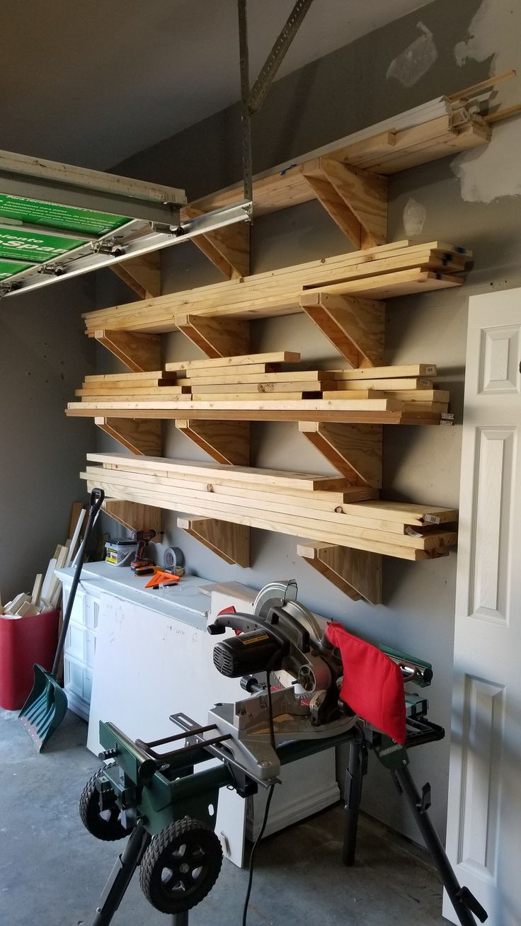 a workbench with tools and wood planks hanging from it's ceiling