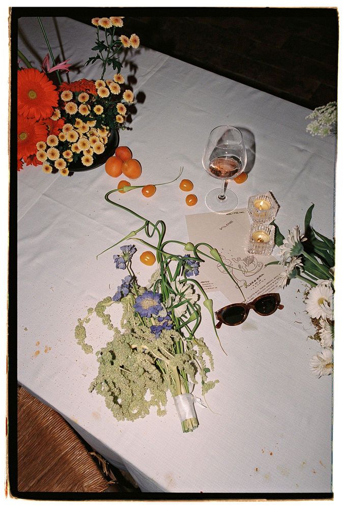 an arrangement of flowers and sunglasses on a table