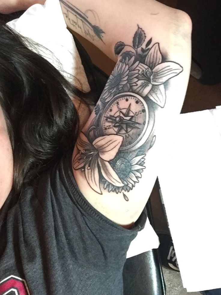 a woman with a clock tattoo on her arm and hand is sitting in a chair