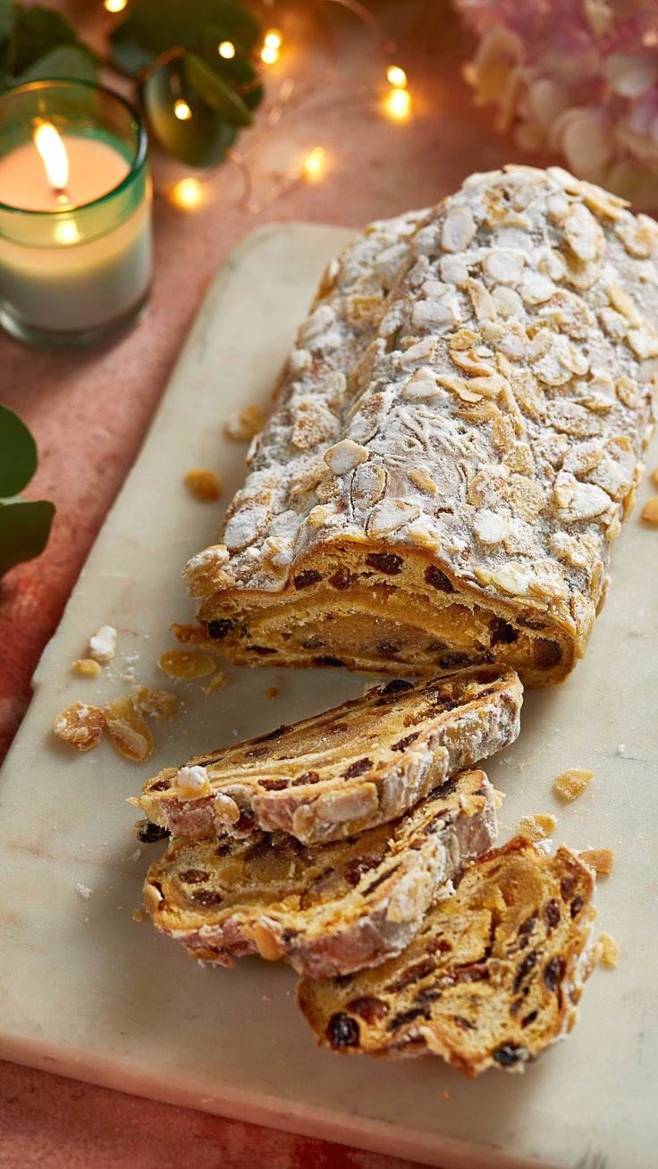 Christmas stollen with slices cut out on a marble board Mary Berry Stollen, Marzipan Stollen Recipe, Christmas Breads For Gifts, Holiday Baking Bread, Easy Stollen Recipe, German Christmas Stollen Recipe, German Christmas Bread, Marzipan Stollen, Stollen Cake