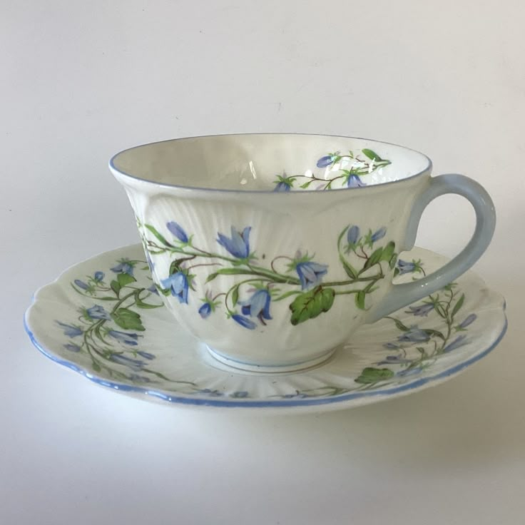 a cup and saucer decorated with blue flowers