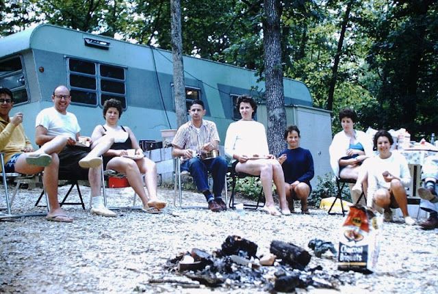 a group of people sitting in chairs next to an rv