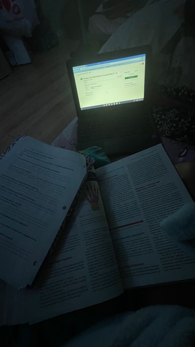 an open laptop computer sitting on top of a book