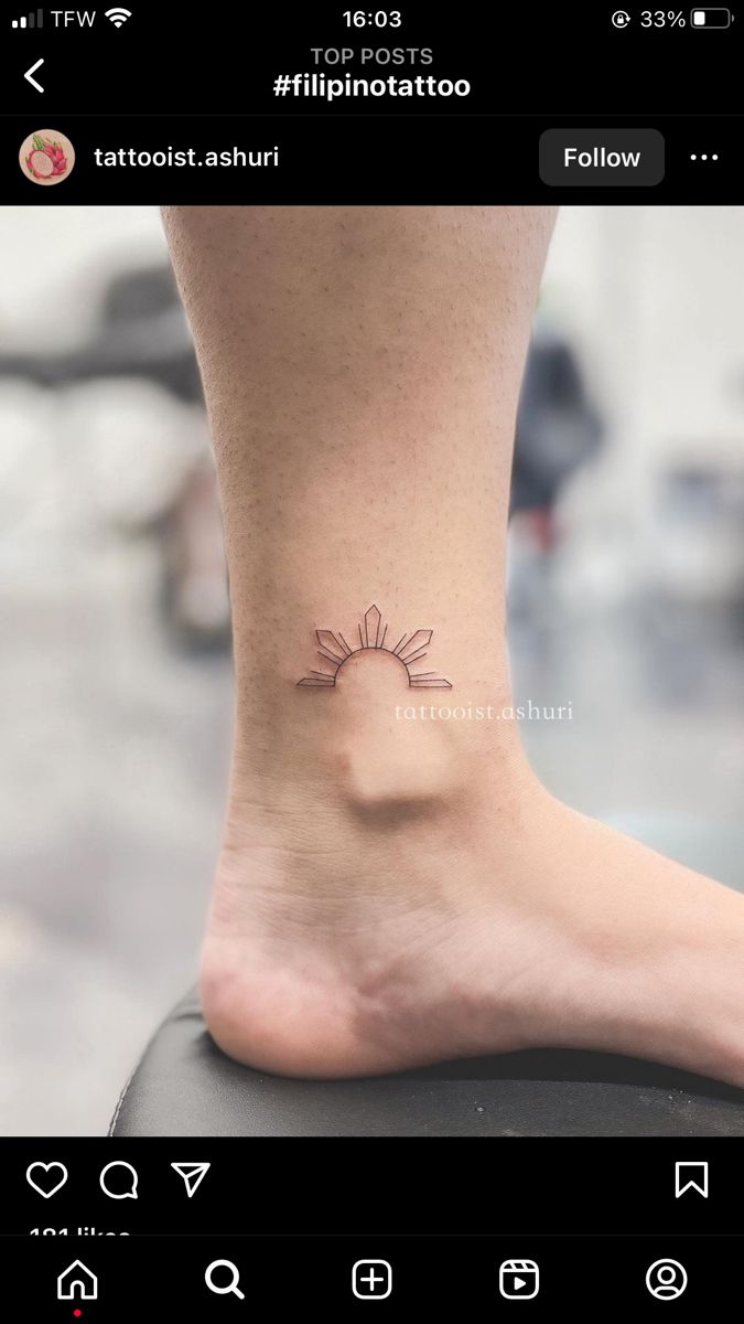 a small tattoo on the foot of a person's leg, with an image of a flower in the center