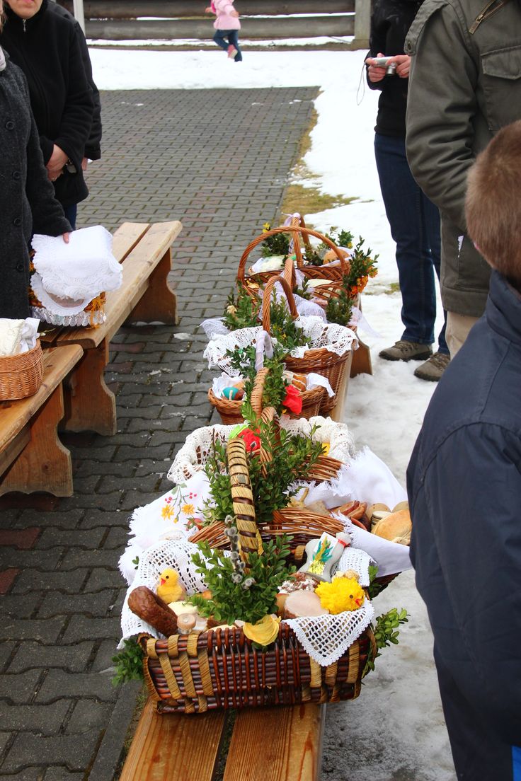 people are standing near picnic tables with baskets full of food