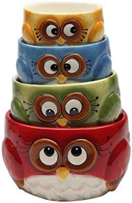 four owls are stacked up in the shape of a stack with eyes painted on them