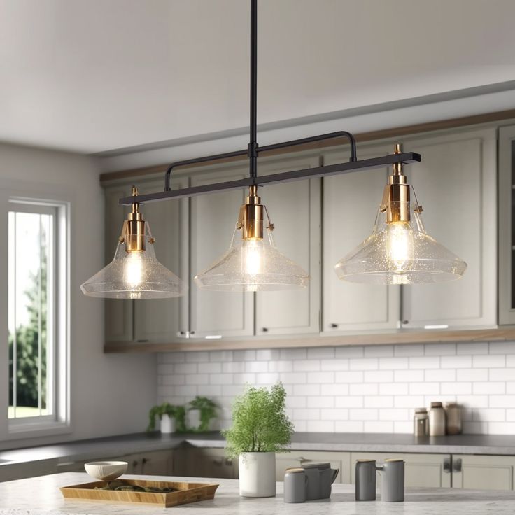 three lights hanging over a kitchen counter top