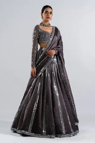 Black lehenga with real hand cut mirror embellishments. Comes with heavily embellished full sleeve blouse and mirror work dupatta.
Components: 3
Pattern: Embellished
Type Of Work: Mirrors
Neckline: V-Neck
Sleeve Type: Straight Full
Fabric: Lehenga and Dupatta - Satin Organza, Blouse - Georgette
Color: Grey
Other Details: 
Linear pattern mirror work
Tiny scalloped hem dupatta and lehenga
Back scoop neck with tassel tie-up
Closure: Blouse: Back hook-eye with tie-up
Occasion: Reception, Sangeet - A Grey Lehenga, Vani Vats, Mirror Work Lehenga, Lehenga Dupatta, Black Lehenga, Mirror Work Blouse, Grey Mirror, Full Sleeve Blouse, Georgette Dupatta