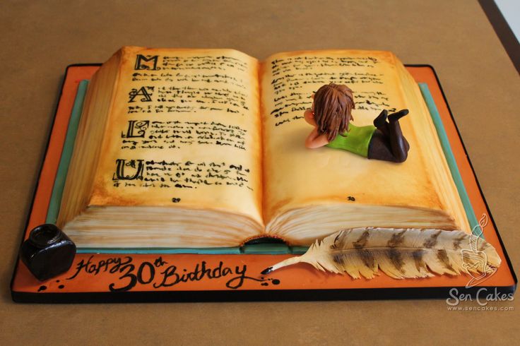 a cake made to look like an open book with a woman on it and a feather