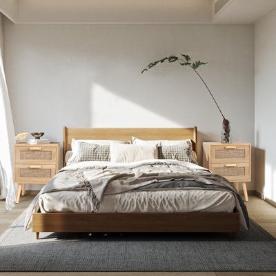 a bedroom with a bed, dressers and a potted plant in the corner