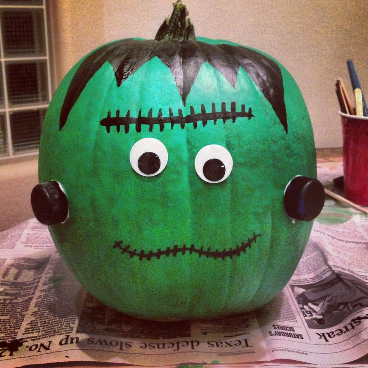 a green pumpkin with black ears and eyes